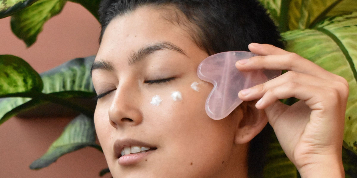 woman using gua sha facial device